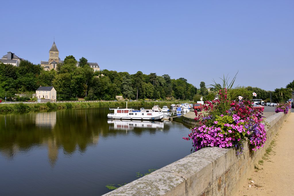 port on mayenne river at château gontier with the saint jean baptiste church in the background, commune in the mayenne department, pays de la loire region, in north western france port on mayenne river at château gontier with the saint jean baptiste church in the background, commune in the mayenne department, pays de la loire region, in north western france